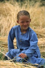 Sourire d'une fillette ladakhi assise dans un champ Inde