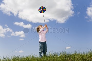 Girl playing with a multicolored windmill France