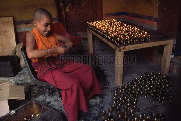 Young monk polishing the oil lamps Ladakh