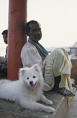 Hund liegt neben einem Mann Uttar Pradesh Indien