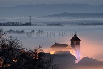 Church lit and fog on Lake Geneva