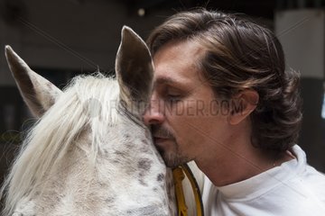 Riding instructor whispering in the ear of a horse