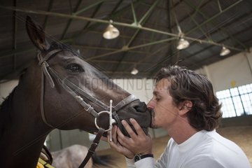 Riding instructor kissing a horse - Argentina
