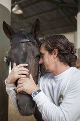 Riding instructor cuddling a horse - Argentina