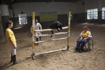Women and dog jumping in a horse therapy center