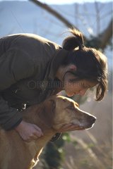 A young girl caressing a dog