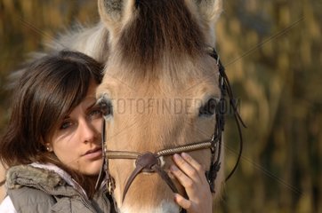 Portrait of young woman and Pony Fjord in winter - France