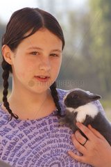 Adolescente portant un lapin gris