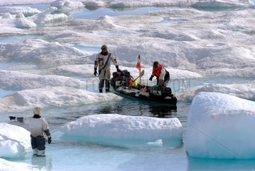 Hauling of kayak on the ice melting in summer Arctic