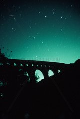 Deux étoiles filantes dans le ciel étoilé du Pont du Gard