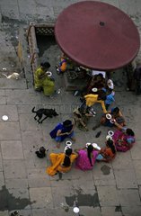 Frauen  die auf der Straße essen und Hunde Vârânaçî India