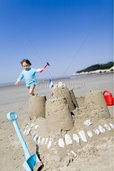 Girl and sandcastle on the beach Charentes France