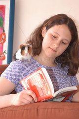 Teenager liest mit einem Trikolor -Meerschweinchen