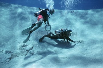 Divers retrieving treasure from blown hit Bahamas