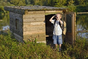 A boy looking through binoculars at a lookout France