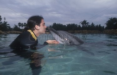 Homme embrassant un dauphin dans l'eau
