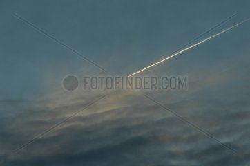Avion laissant sa trace dans un ciel nuageux