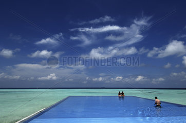 Olhuveli resort  a couple is enjoying a quiet moment in the swimmingpool
