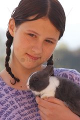 Adolescente portant un lapin gris
