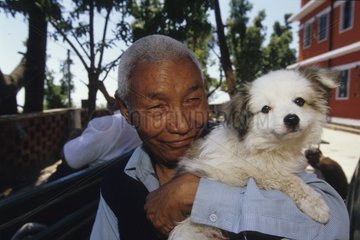 Nobody old carrying a dog in its arms India