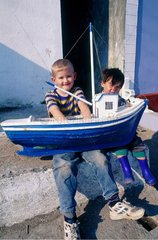 Children holding a model boat Toraigh Island Ireland