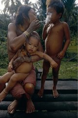 Mentawai woman lighting the cigarette of her child Siberut