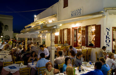 Night photo of beautiful Mykonos Greece and restaurant called Taverna Nikos in downtown shopping