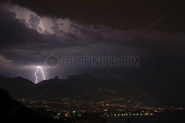 Lightnings illuminating a cumulonimbus over a city