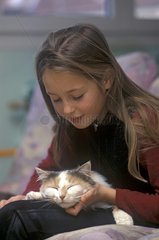Young girl caressing a cat