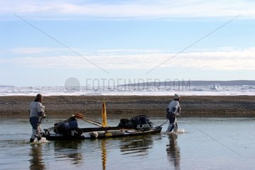 Männer spazieren gehen  um ihr Kajak am Ufer -Arktis zu schleppen