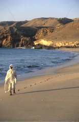Omanais  der an einem Strand -Sultanat Oman geht