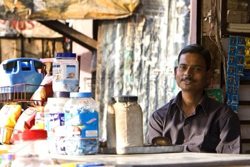 Salesman sitting in his shop Uttar Pradesh India