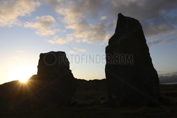 Hintergrundbeleuchtete Menhirs bei Sunset Irland