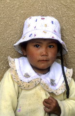 Young child portrait aged 3 with hat in capital city of Lhasa Tibet China