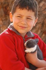Enfant tenant un lapin gris