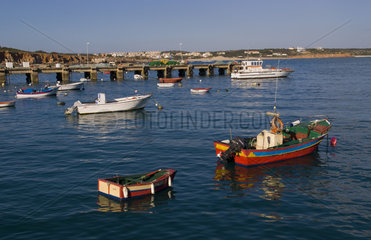Colorful boats in water in the Southernmost part of Portugal Algarve in village of Porta de Sagres
