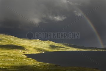 Regenbogen oben auf einem Bergsee Norwegen