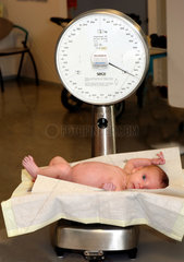 10052092 Baby op weegschaal tijdens controle bij consultatieburo