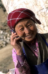 Older native woman on cell phone in rural Tibet China