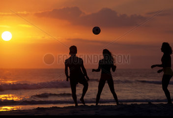 Young people play soccer at Ipanema beach during sunset. Rio de Janeiro  Brazil. Lifestyle  couple  woman  leisure time  fun  youth  sports with ball.