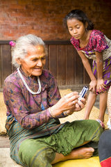 Great image of modern technology with old woman and new PDA computer in village of Bhaktapur a town near Kathmandu Nepal