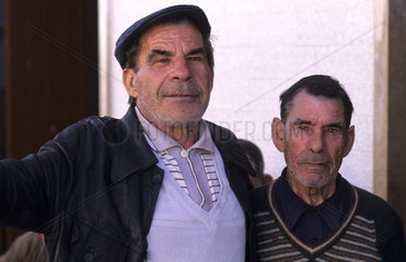 Tough and rough old fishermen relaxing at a bar in the village of Olmao in the Algarve in Southern Portugal in Europe