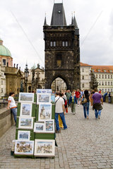 Crowds and artists on the famous Charles Bridge of tourist city of Prague in Czech Republic