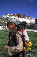 Native woman with child on her back in rural country outside the city of Lhasa Tibet China