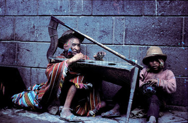 Peru  Cusco; Indian street musicians playing harp in the street to make some money.