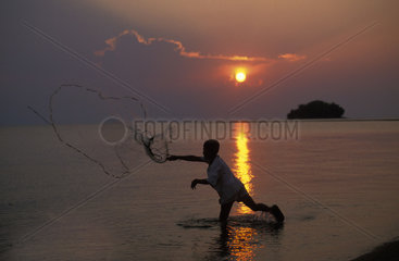 Malaysia  Tioman island  a boy fishing by throwing his net