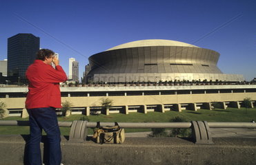 Man taking picture of beautiful famous Super Dome stadium in wonderful city of New Orleans Louisiana NOLA USA
