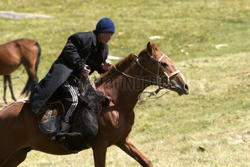 Young nomadic horseman galloping in a meadow Kyrgyzstan