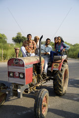 Anything that drives carries people as tractor has passengers on dangerous roads between Delhi and Jodhpur in India