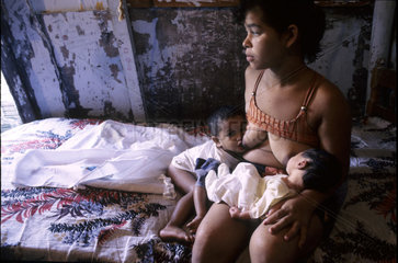 Parenting teenager. Young mother breast-feeds her two babies  poverty in Northeastern Brazil.
